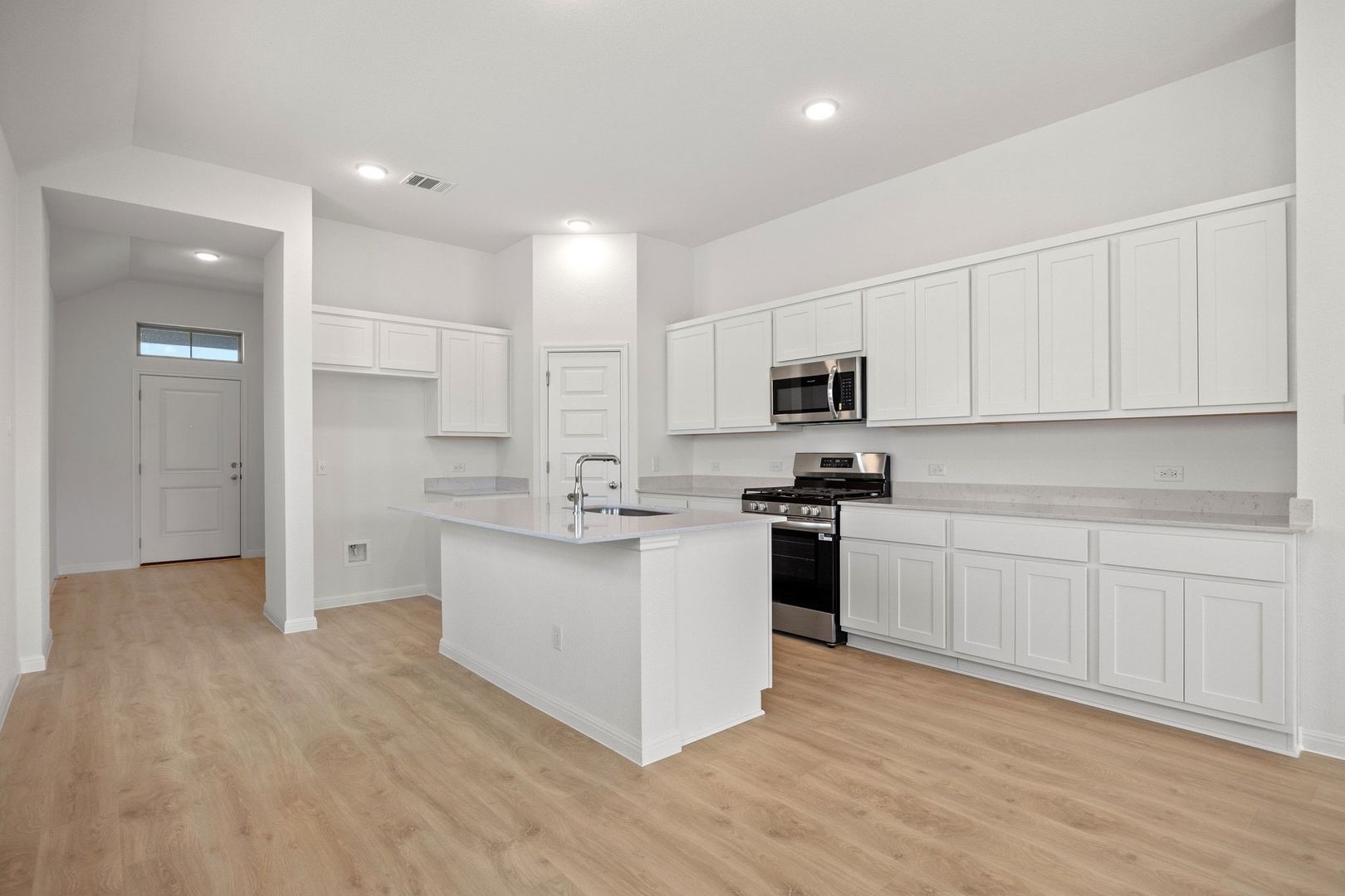278 Bendecido Loop Elgin, TX 78621 - Photo 10 of 37 a kitchen with granite countertop white cabinets and stainless steel appliances