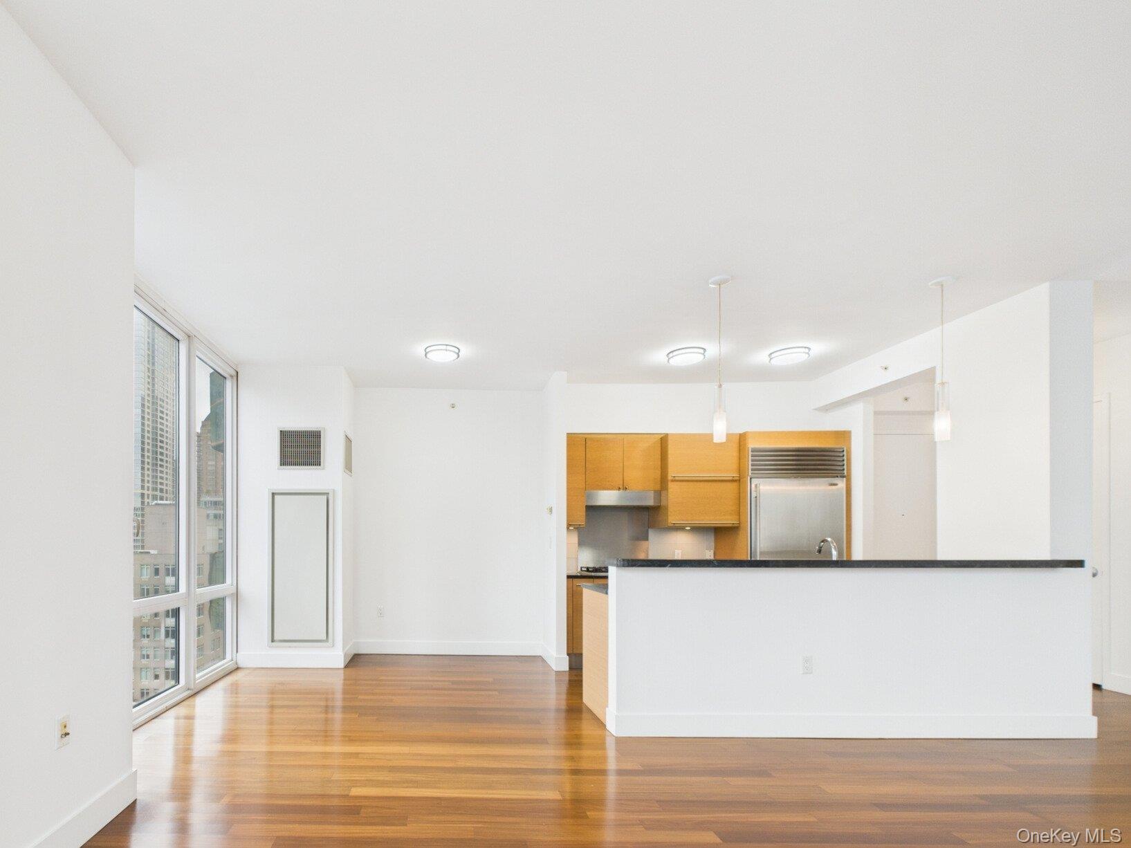 10 West End Avenue, Unit 20B Manhattan, NY 10023 - Photo 41 of 41 Kitchen with decorative light fixtures, dark wood finished floors, expansive windows, built in refrigerator, and open floor plan
