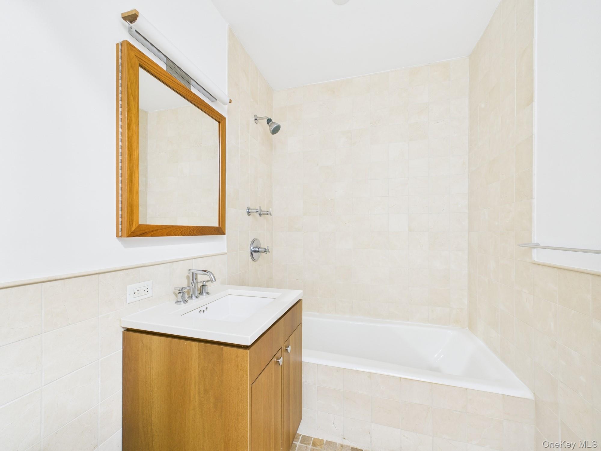10 West End Avenue, Unit 20B Manhattan, NY 10023 - Photo 27 of 41 Bathroom with tile walls, vanity, and tiled shower / bath