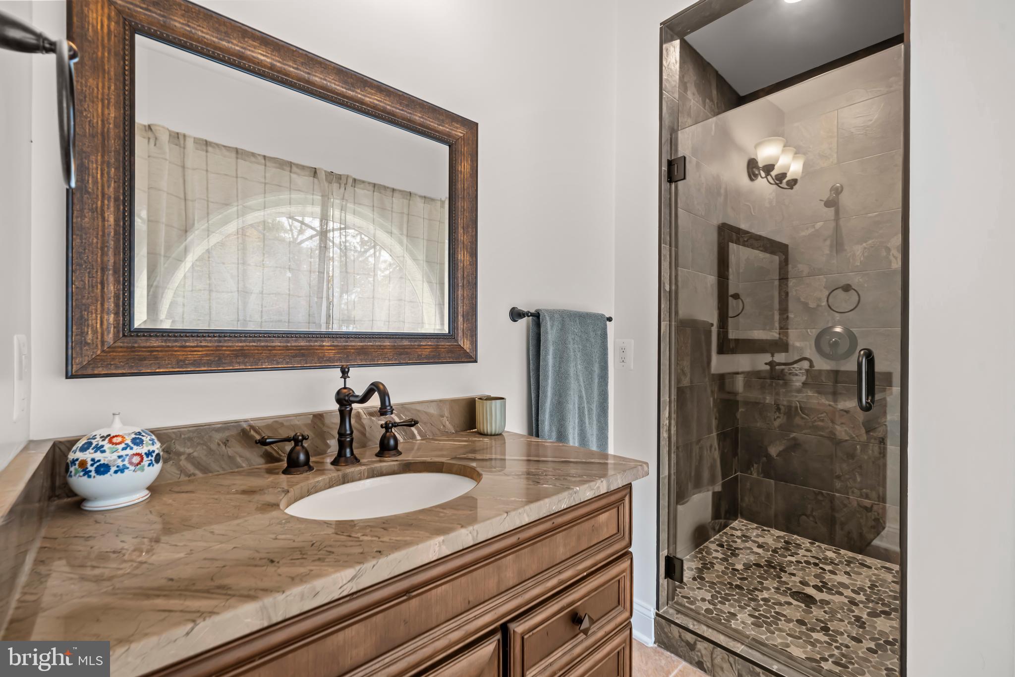 13025 Yates Ford Road Clifton, VA 20124 - Photo 47 of 82 a bathroom with a granite countertop sink a mirror and shower