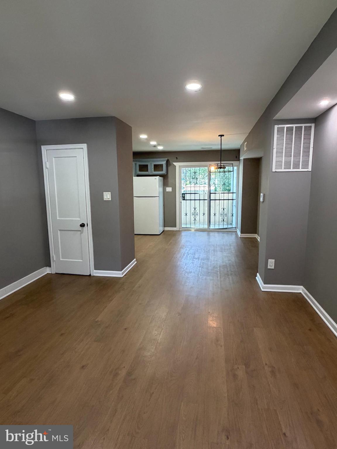 1353 Cambria Street Baltimore, MD 21225 - Photo 5 of 23 a view of an empty room with window and wooden floor