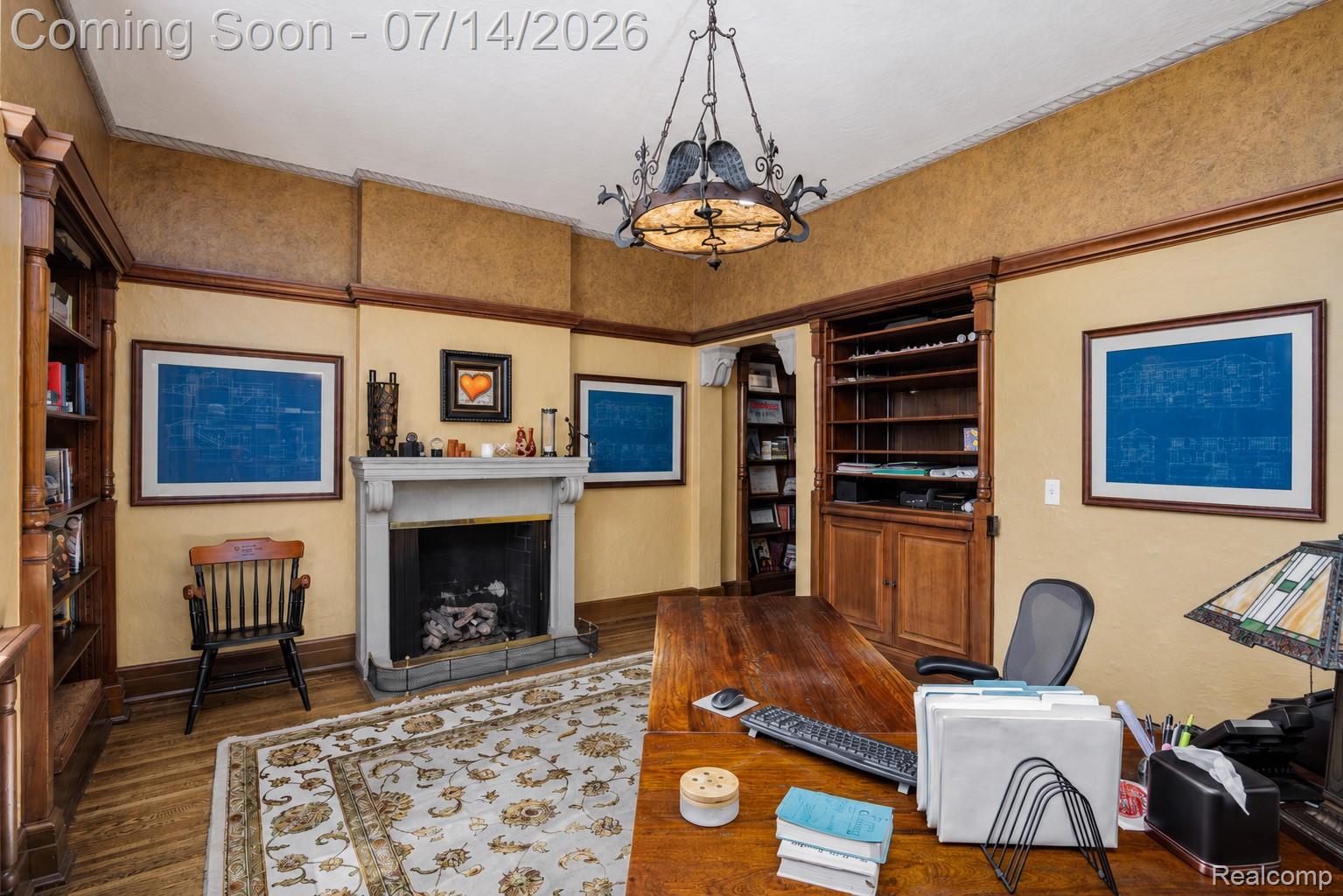 189 Cloverly Road Grosse Pointe, MI 48236 - Photo 36 of 96 Hardwood flooring with an ornamental rug, a stone-mantled fireplace, built-in shelving, custom cabinetry, and a decorative overhead light fixture