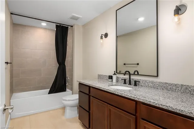 a bathroom with a granite countertop sink toilet and shower