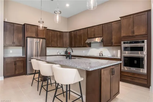 a kitchen with stainless steel appliances granite countertop a sink refrigerator and microwave