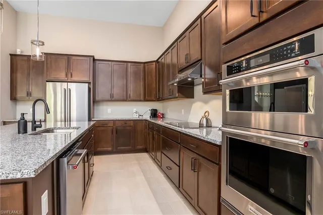 a kitchen with stainless steel appliances granite countertop a sink stove and refrigerator