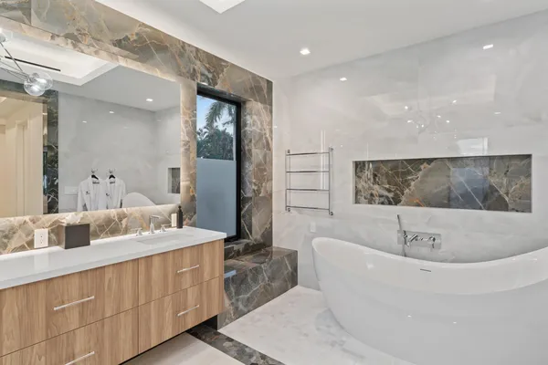 a bathroom with a sink mirror and a bath tub