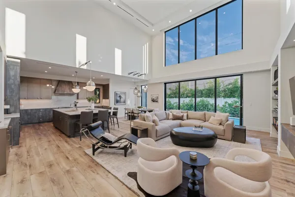 a dining room with wooden floor a chandelier a wooden table and chairs