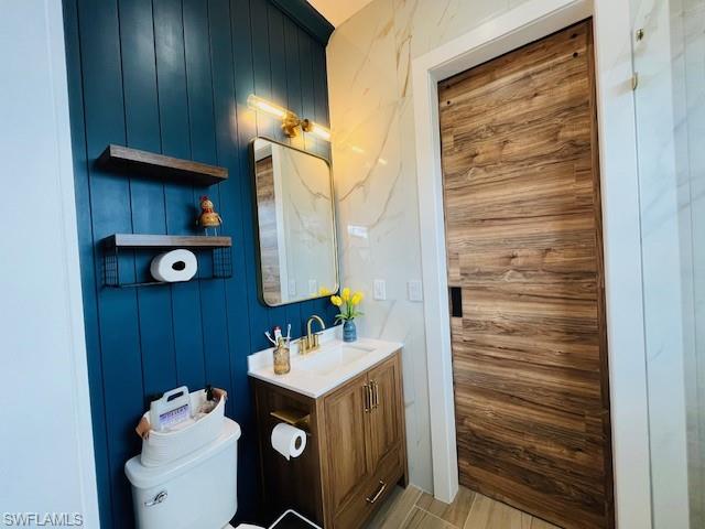 4795 Rosetta Terrace Immokalee, FL 34142 - Photo 14 of 27 Bathroom featuring vanity, wooden walls, and light wood-type flooring