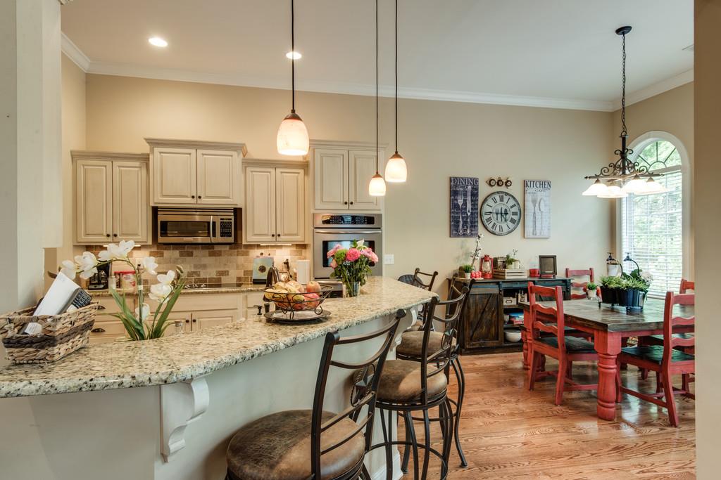 7302 Allans Ridge Lane Fairview, TN 37062 - Photo 11 of 30 a kitchen with stainless steel appliances kitchen island granite countertop a table chairs and a refrigerator