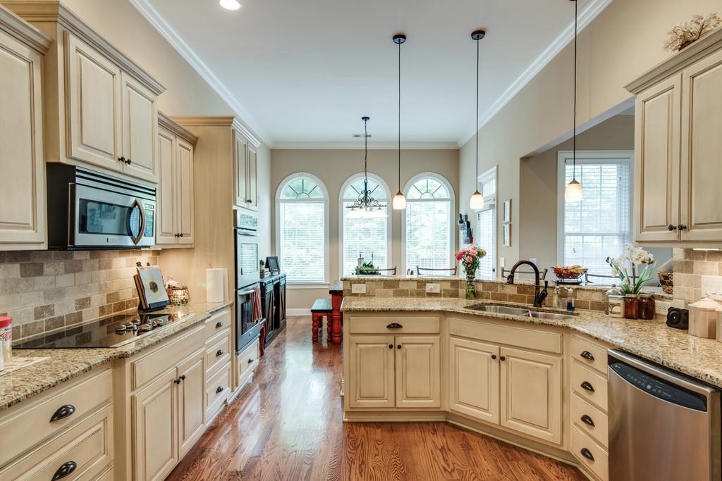 7302 Allans Ridge Lane Fairview, TN 37062 - Photo 13 of 30 an open kitchen with granite countertop a sink a stove cabinets and wooden floor