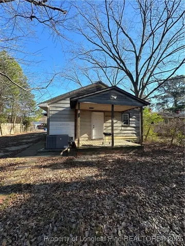 a view of a house with backyard and trees