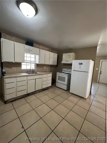 a kitchen with cabinets and white stainless steel appliances