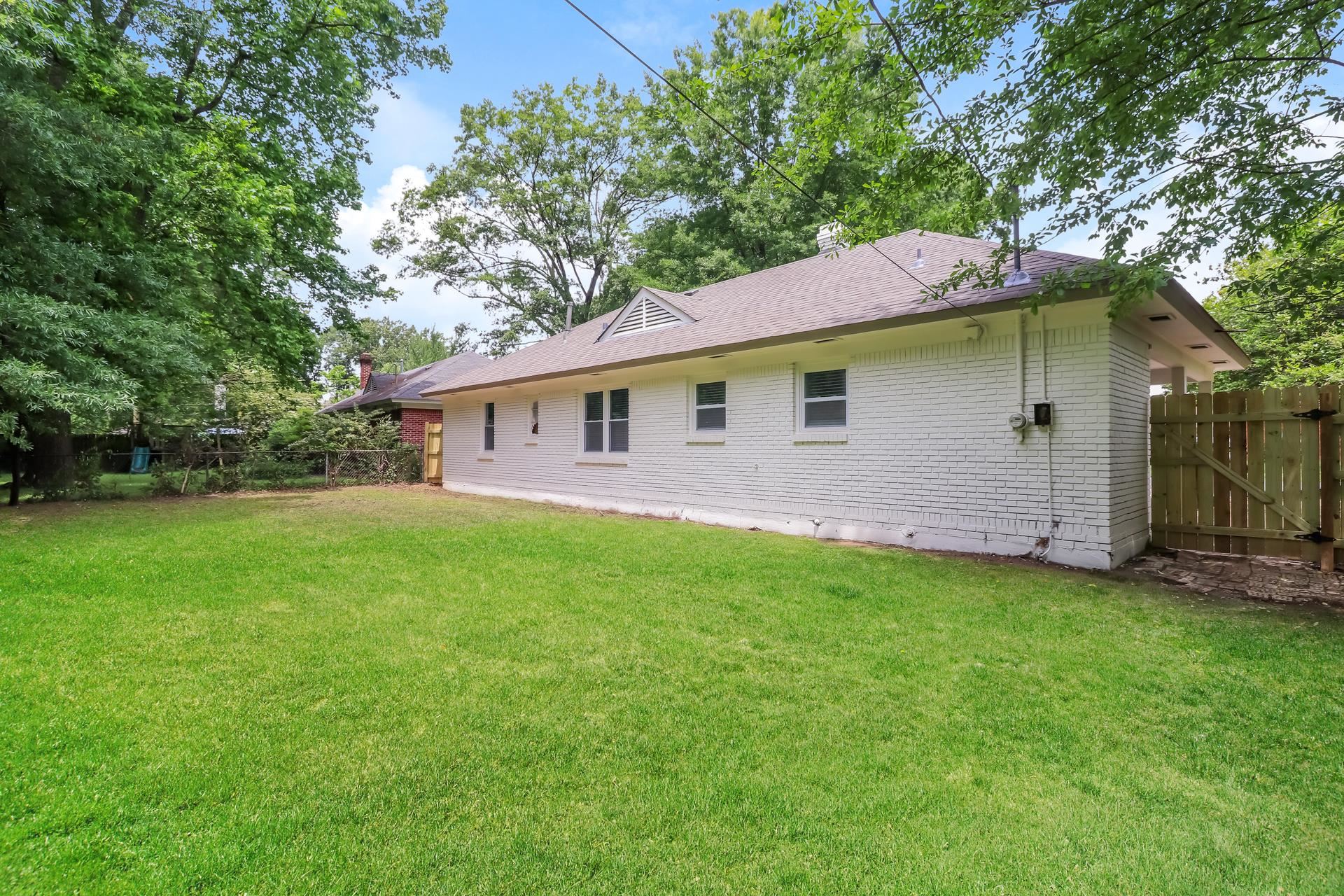 5113 Helene Road Memphis, TN 38117 - Photo 18 of 18 a backyard of a house with large trees and entertaining space