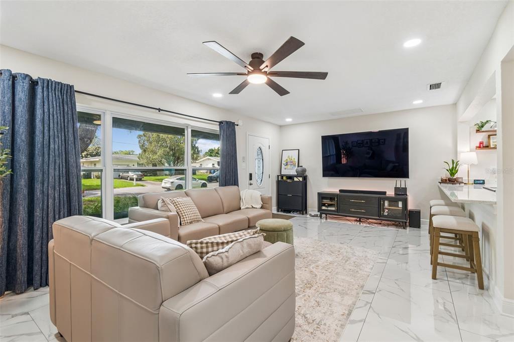 1618 Barry Road Clearwater, FL 33756 - Photo 13 of 71 a living room with furniture a ceiling fan and a flat screen tv