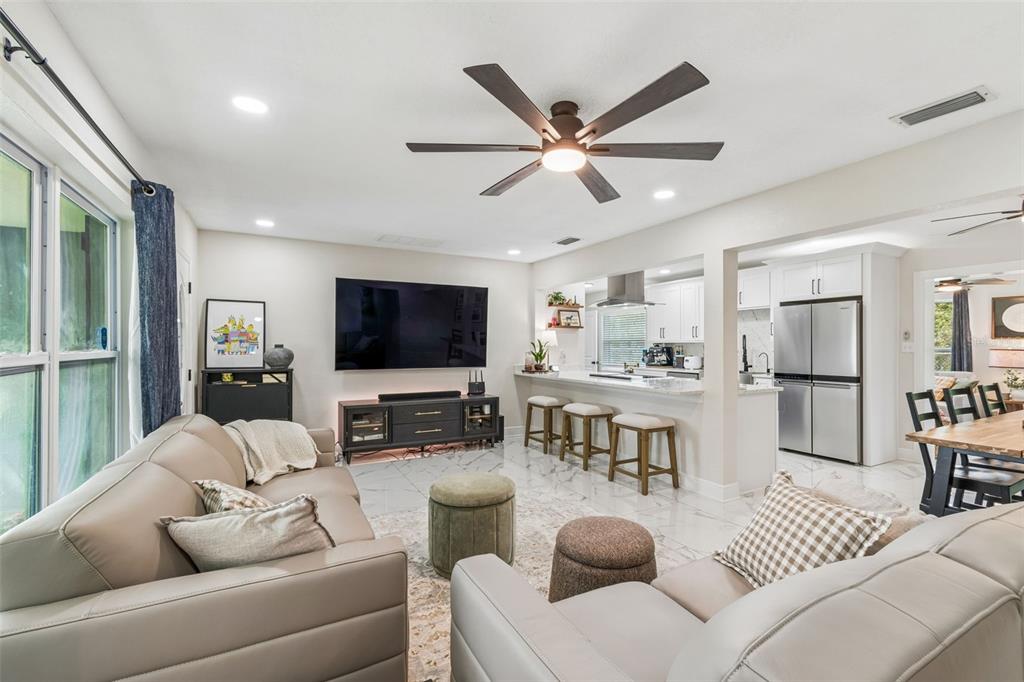 1618 Barry Road Clearwater, FL 33756 - Photo 15 of 71 a living room with furniture a flat screen tv and a chandelier