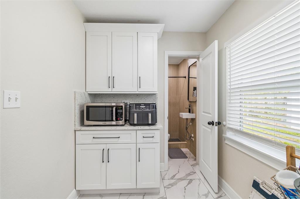 1618 Barry Road Clearwater, FL 33756 - Photo 25 of 71 a kitchen with white cabinets and white appliances