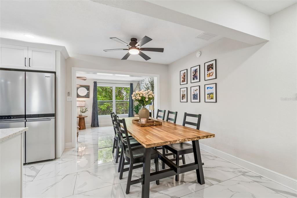 1618 Barry Road Clearwater, FL 33756 - Photo 29 of 71 a dining room with furniture a kitchen view and a refrigerator