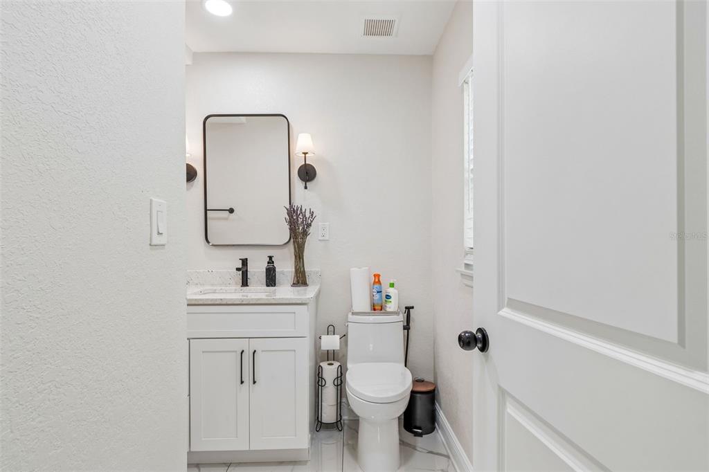 1618 Barry Road Clearwater, FL 33756 - Photo 42 of 71 a bathroom with a toilet sink vanity and mirror