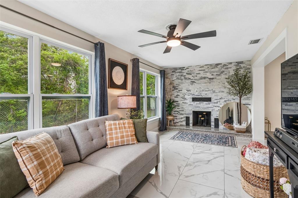 1618 Barry Road Clearwater, FL 33756 - Photo 48 of 71 a living room with furniture a fireplace and a large window