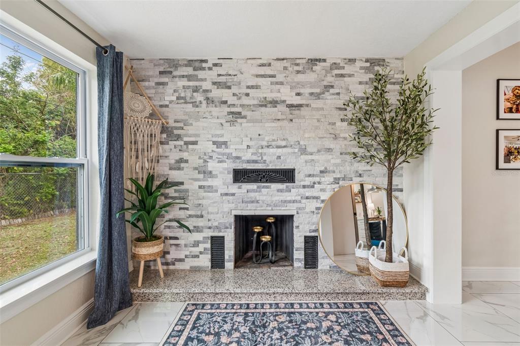 1618 Barry Road Clearwater, FL 33756 - Photo 50 of 71 a living room with a fireplace and a potted plant