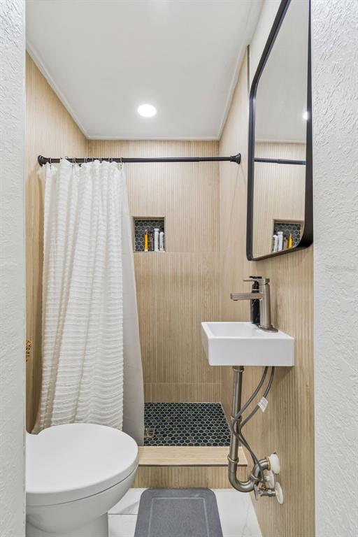 1618 Barry Road Clearwater, FL 33756 - Photo 53 of 71 a bathroom with a toilet a sink and a shower