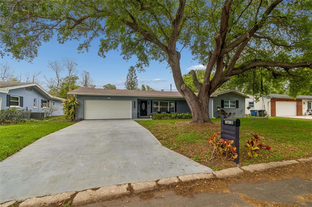 1618 Barry Road Clearwater, FL 33756 - Photo 58 of 71 a front view of a house with a yard and garage