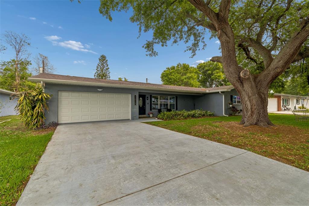 1618 Barry Road Clearwater, FL 33756 - Photo 68 of 71 a front view of a house with a yard and a garage