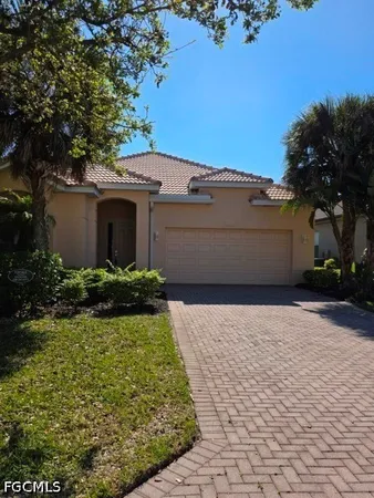 a view of a white house with a yard and large tree