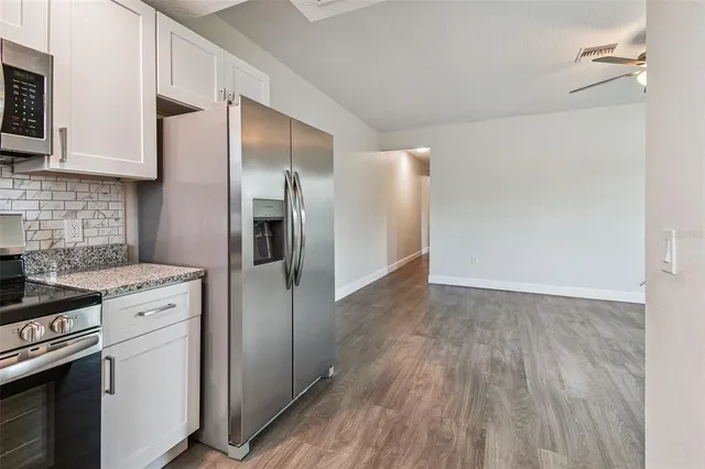 a kitchen with stainless steel appliances granite countertop a refrigerator and a stove top oven