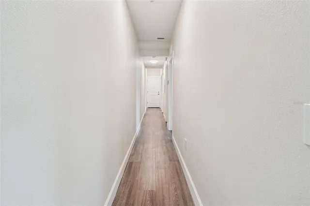 a view of a hallway with wooden floor