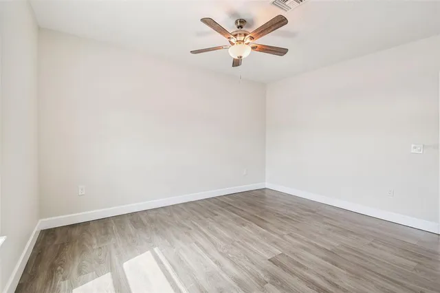 an empty room with wooden floor and a window