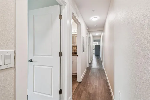 a view of a hallway with wooden floor