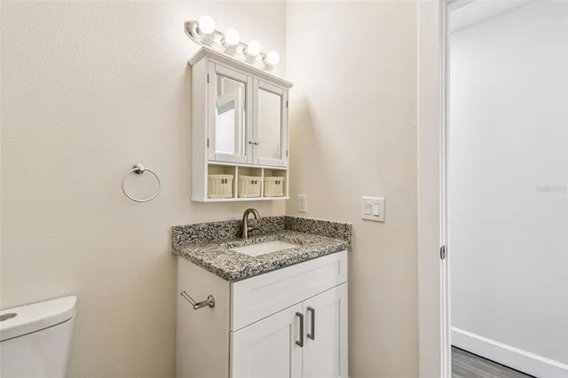 a bathroom with a granite countertop sink and a mirror