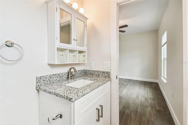 a bathroom with a granite countertop sink and a mirror