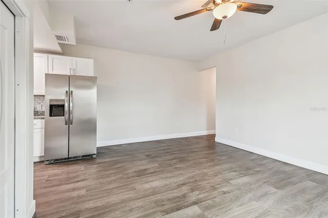 a view of empty room with wooden floor