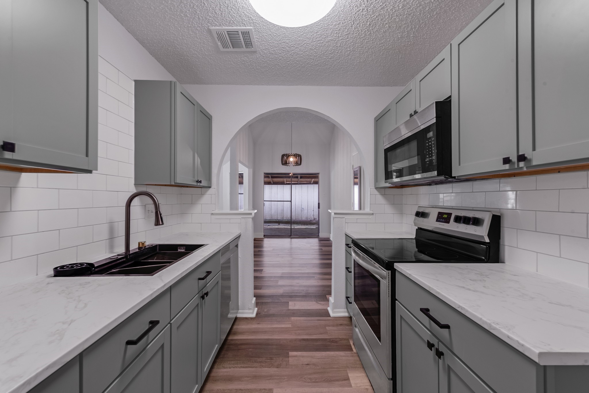 23426 Prairie Bird Drive Spring, TX 77373 - Photo 15 of 34 a kitchen with stainless steel appliances granite countertop a sink a stove top oven and wooden floors