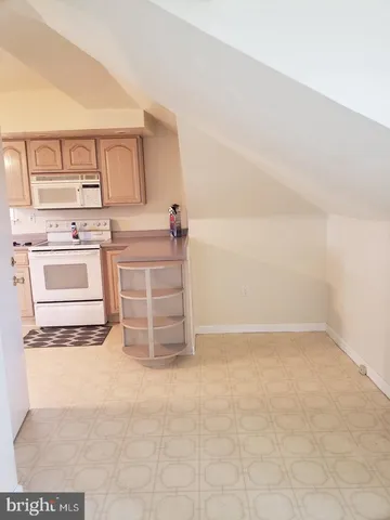 a kitchen with white cabinets and white appliances