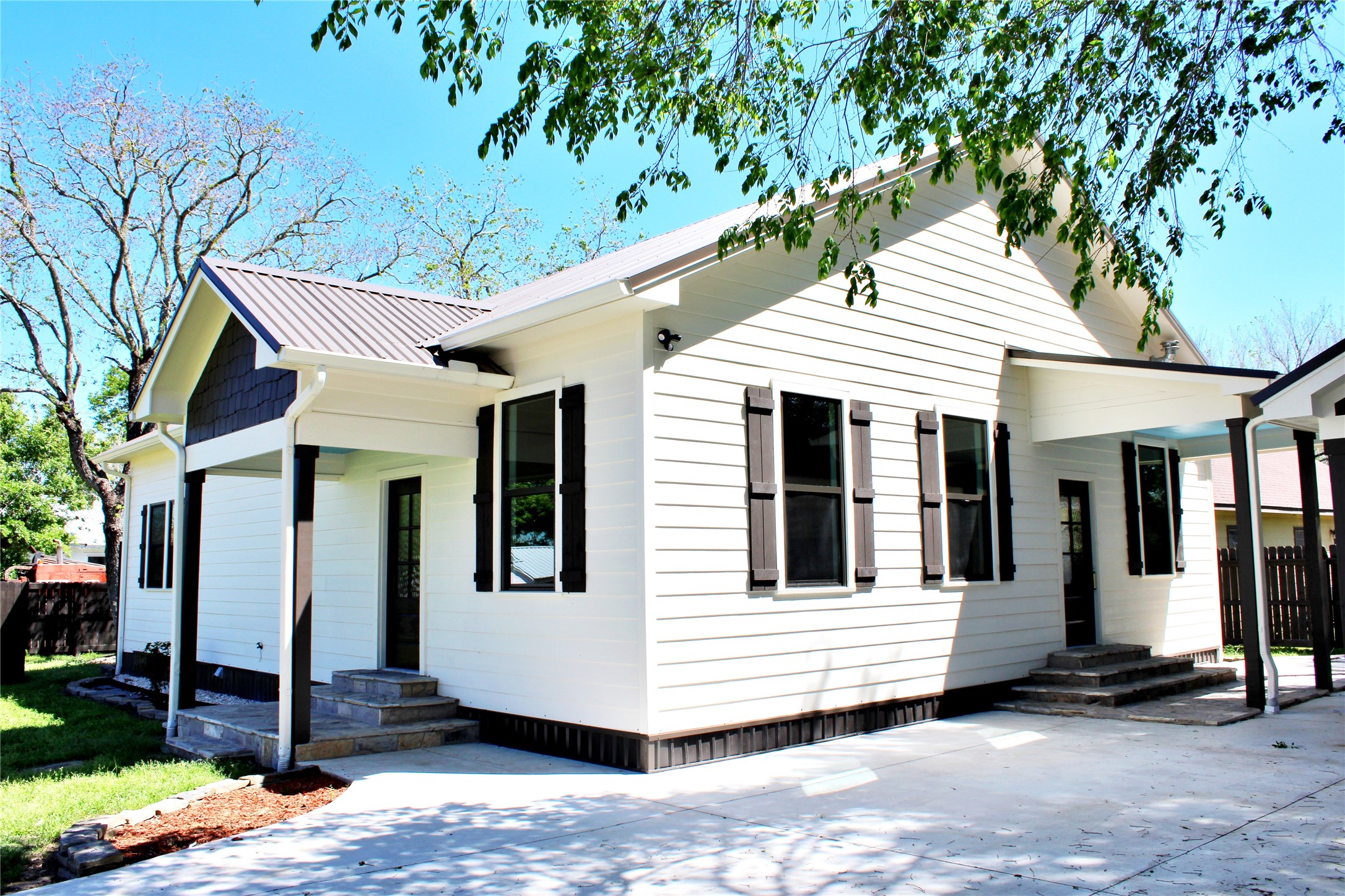678 Colorado Street Glidden, TX 78943 - Photo 37 of 48 a view of a white house with a large windows and large trees