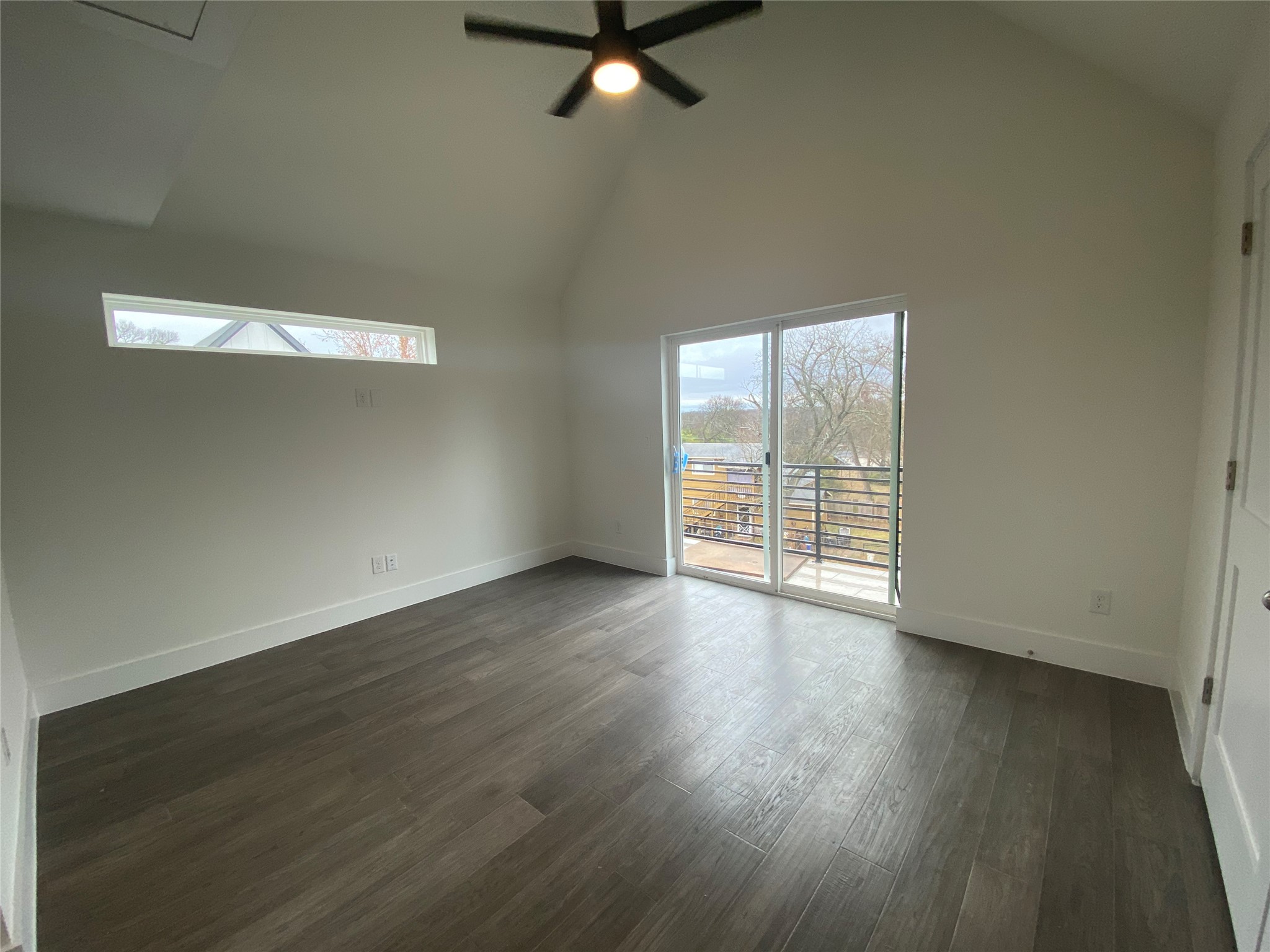 1916 Webberville Road, Unit B Austin, TX 78721 - Photo 13 of 25 Spacious room featuring wood-finish flooring, vaulted ceiling, and white baseboards