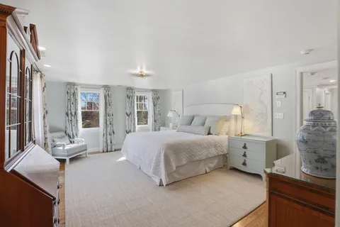 a bedroom with a bed and large windows