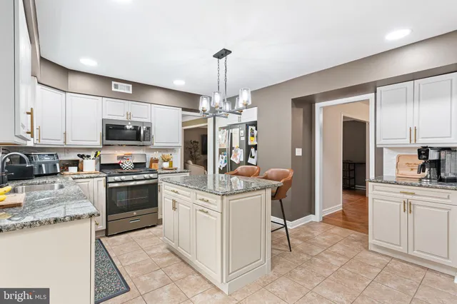 a kitchen with stainless steel appliances granite countertop a stove top oven a sink dishwasher and a refrigerator