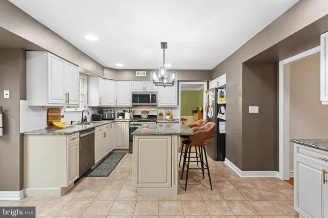 a kitchen with a sink a counter top space appliances and cabinets