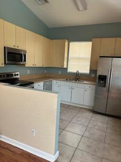 5642 Sunberry Circle Fort Pierce, FL 34951 - Photo 3 of 11 a kitchen with stainless steel appliances a sink a stove a microwave and a refrigerator