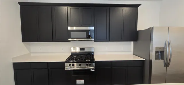 a kitchen with a refrigerator and a stove top oven