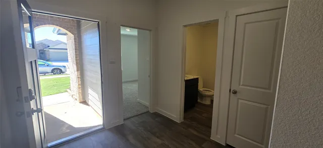 a view of an entryway with wooden floor and a bedroom