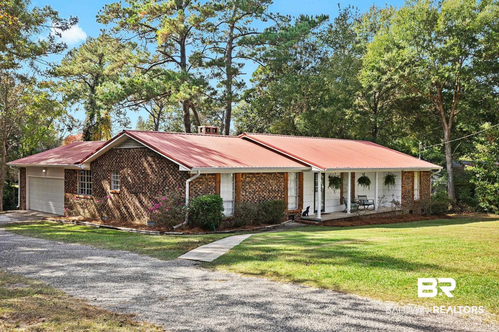 4 Rally Road Spanish Fort, AL 36527 - Photo 3 of 41 Ranch-style house with brick siding, a metal roof, gravel driveway, and view of wooded area