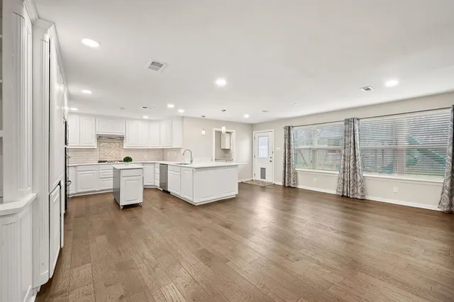 a large white kitchen with a white countertops and cabinets