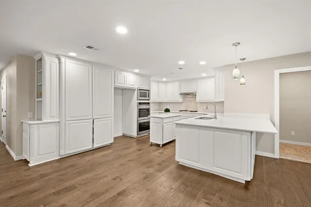 a large white kitchen with a refrigerator a sink and a stove