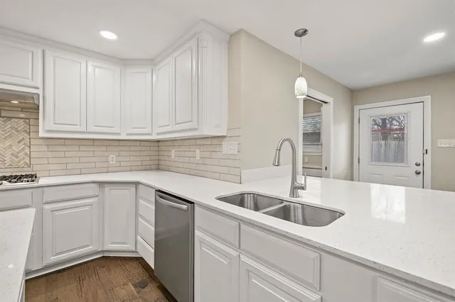 a kitchen with sink white cabinets and window