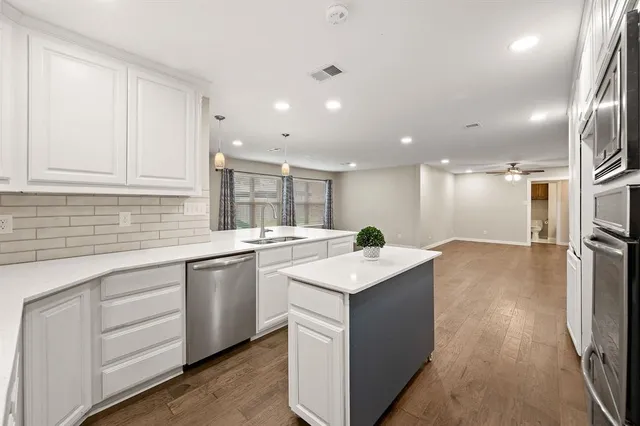 a kitchen with a sink stove and cabinets